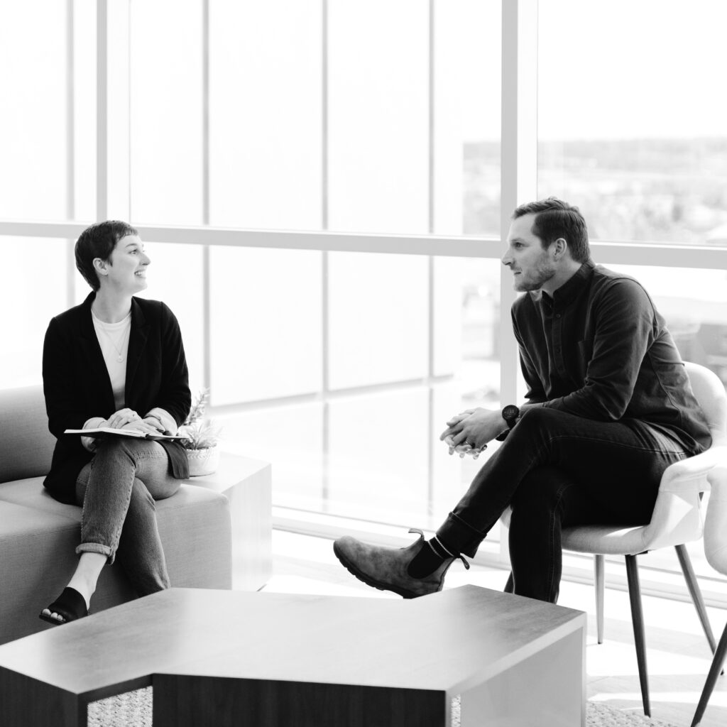 man and woman having a meeting in an office lobby - black and white