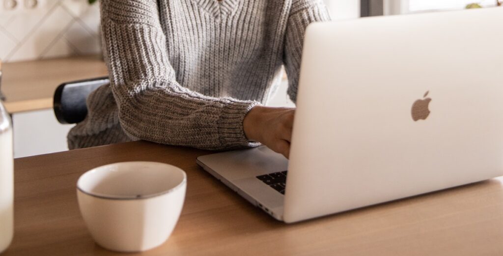 woman at macbook on kitchen counter