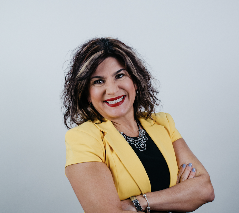 woman smiling wearing yellow short sleeve jacket